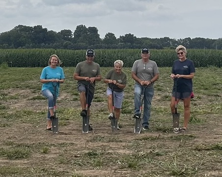 Groundbreaking at Jefferson Park Plaza: five people with shovels in an open field